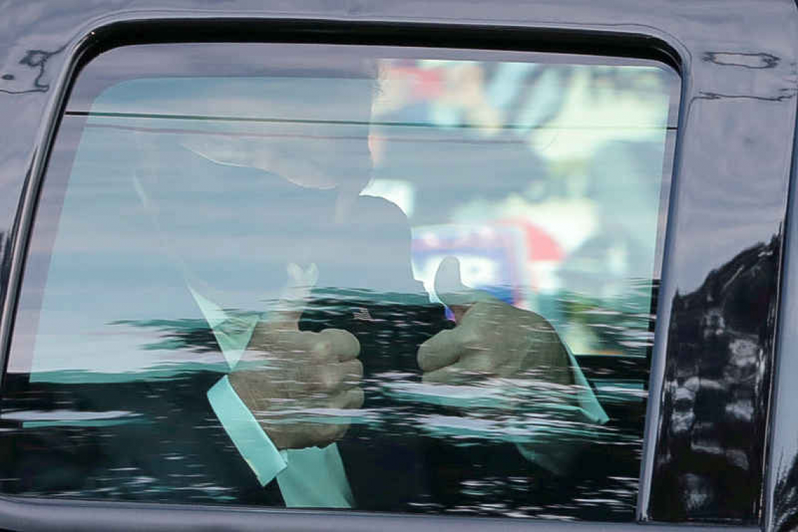 Infected Trump greets supporters in motorcade outside hospital