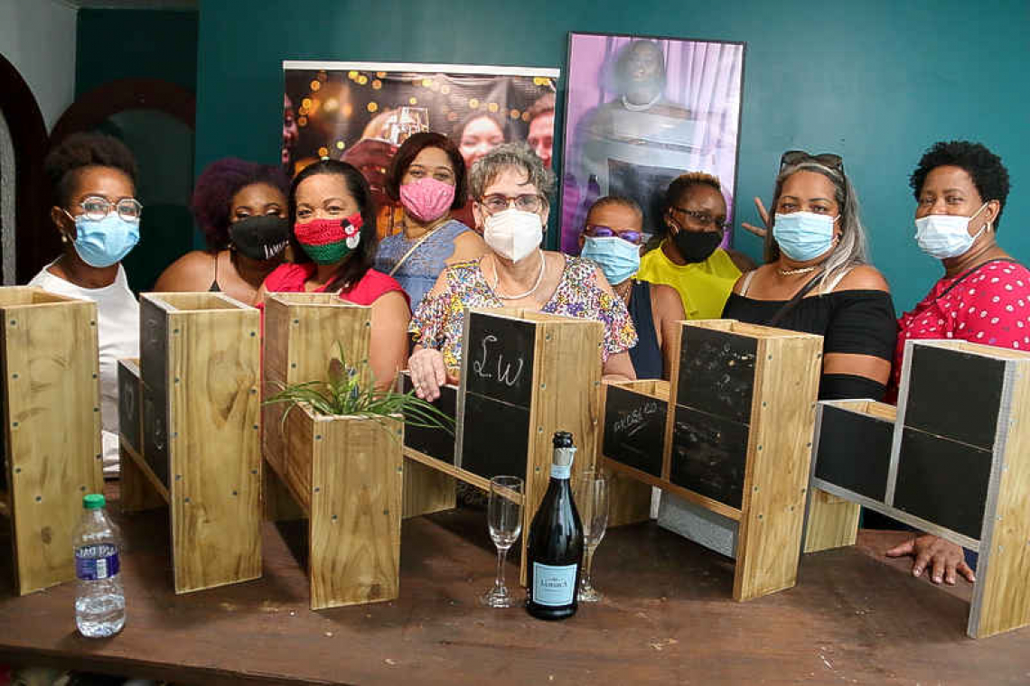 Women learn how to build  planter boxes in workshops