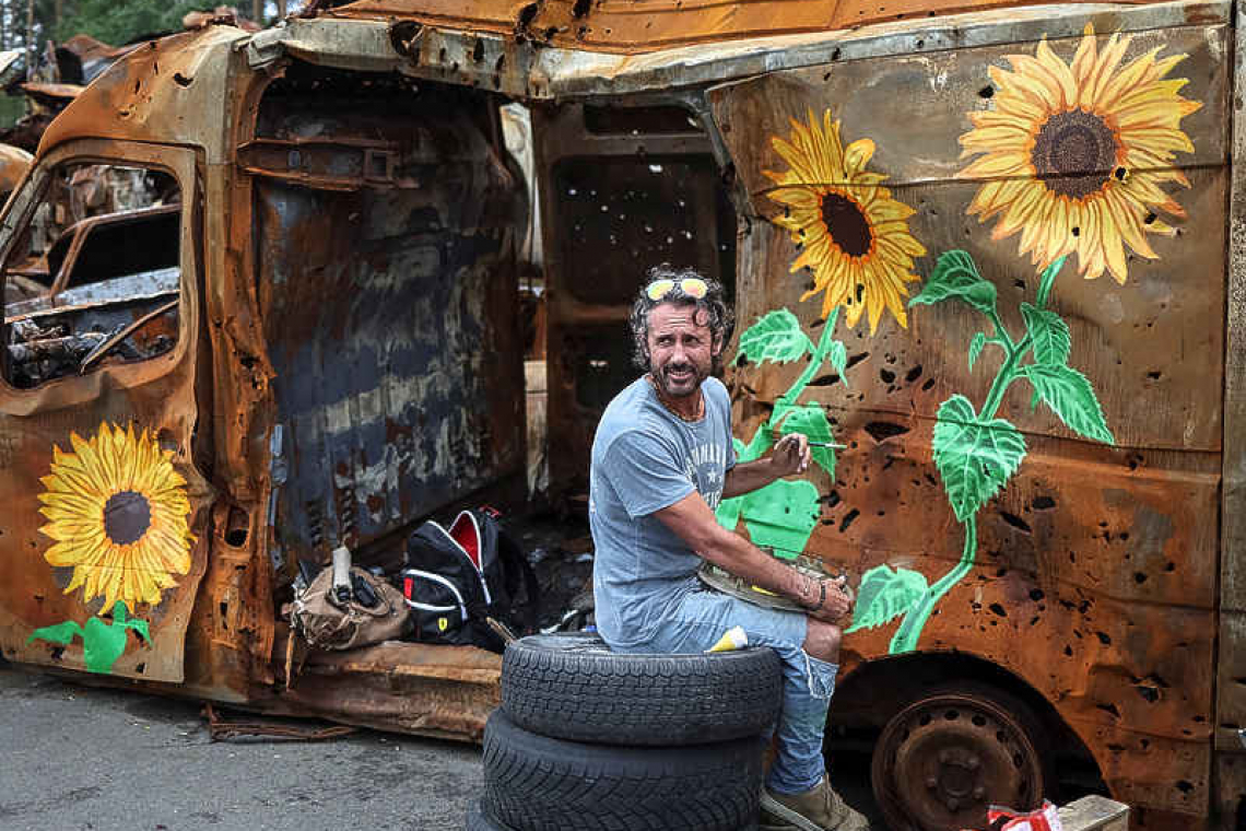 Artists painting flowers over Ukraine war wreckage, unsettling some locals