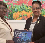 Dr. Richardson presents caretaker  PM Jacobs with legal reference book
